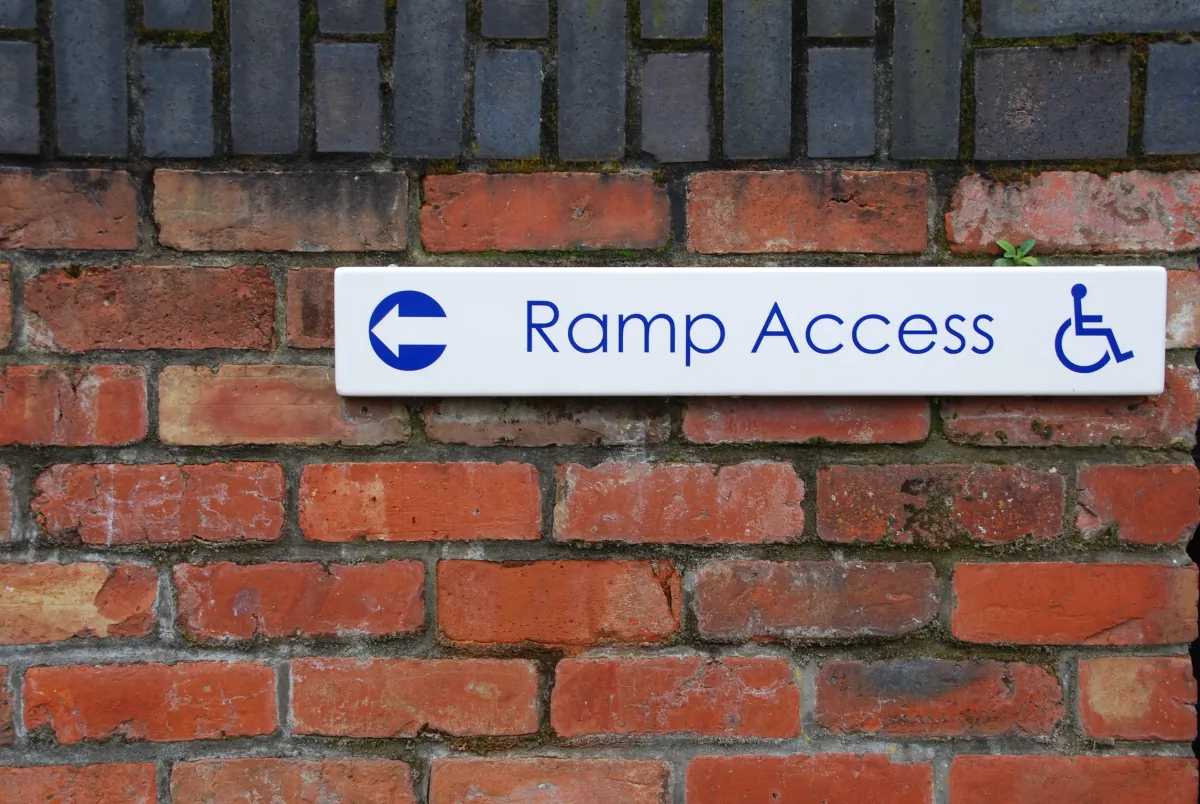 ada compliance upgrades ramp access sign brick wall background