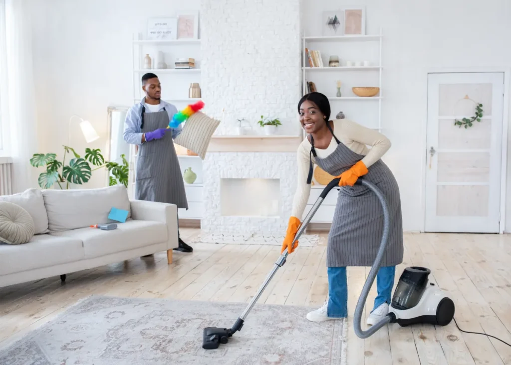 clean jobsite home protection happy black woman vacuuming floor while her boyfri