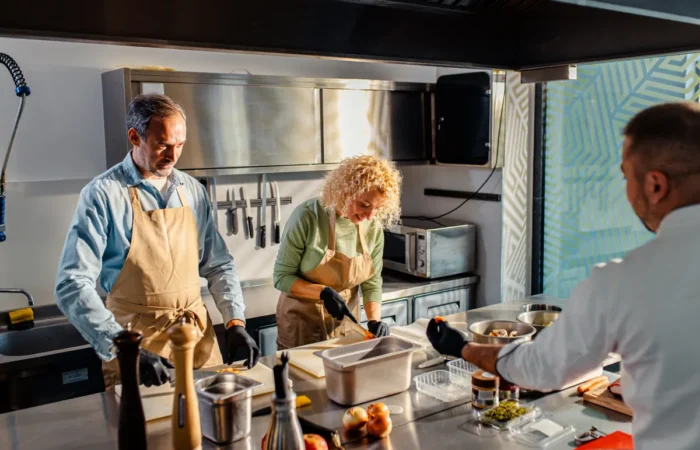 commercial kitchen middle aged couple enjoying cooking class