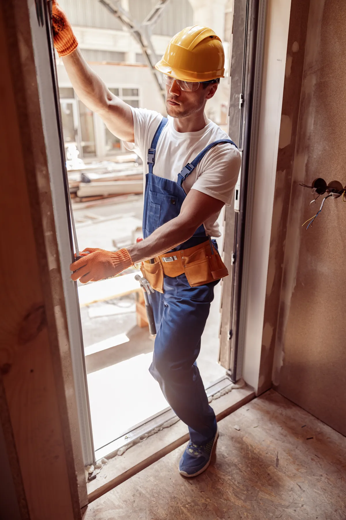 Installer measuring an existing door frame before replacement