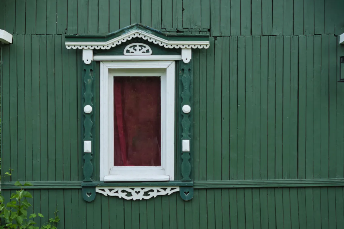 exterior window trim green wooden wall with a closed red door and