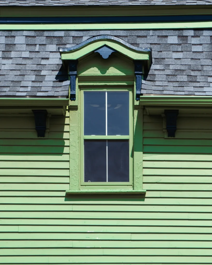 exterior window trim vertical shot of a wooden green window on a