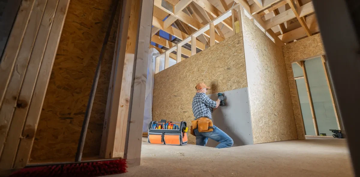 franchise build outs construction worker installs drywall newly fr