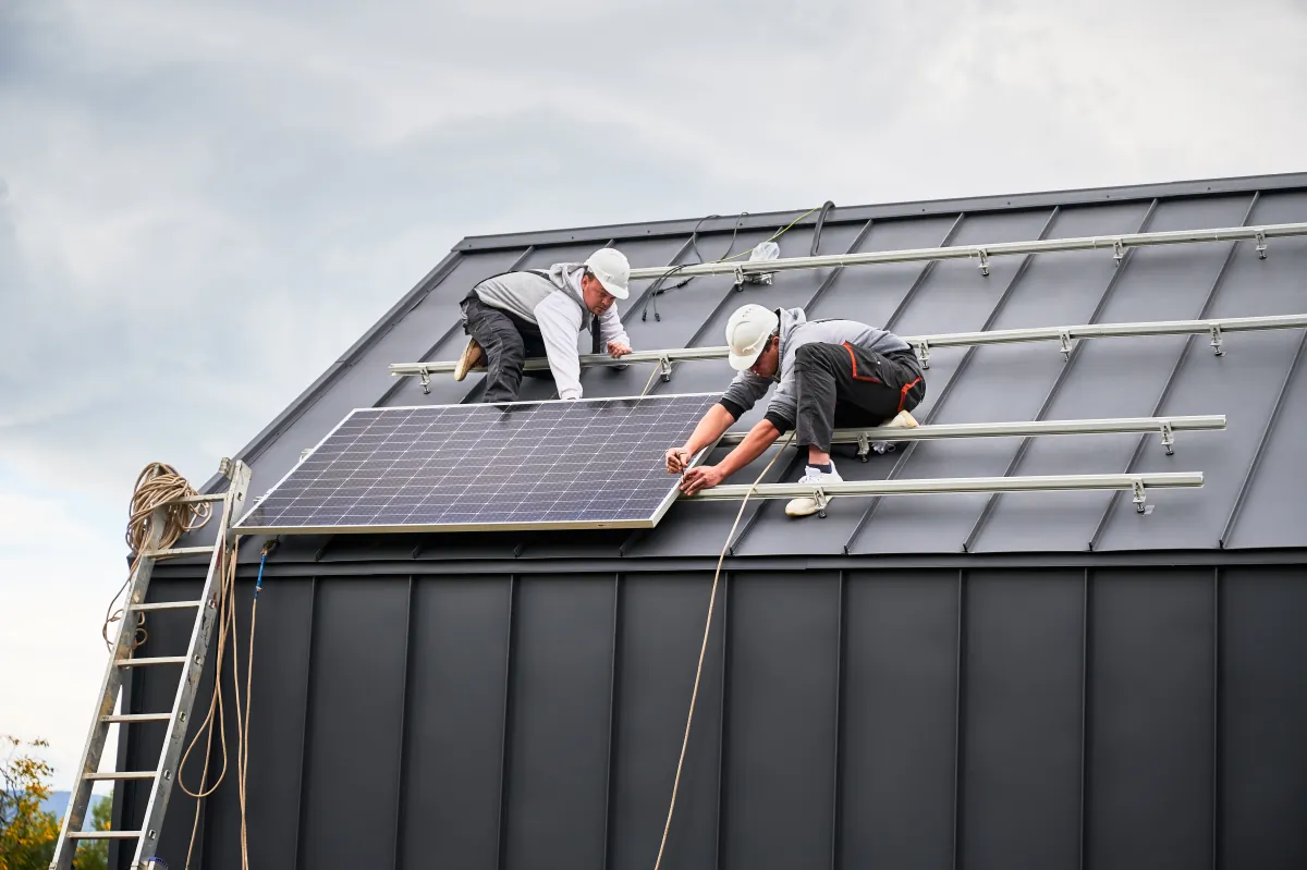 metal roof installation technicians installing photovoltaic solar panels o