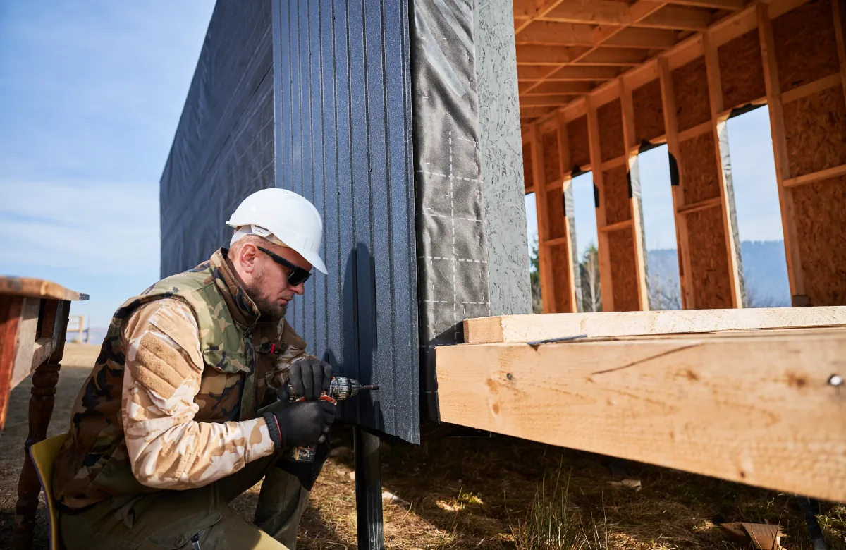 siding builder installing corrugated iron sheet used as f