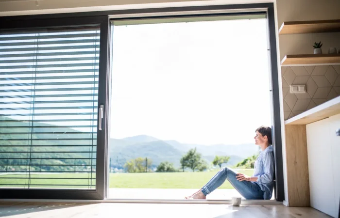 sliding window side view of young woman with coffee sitting by pa