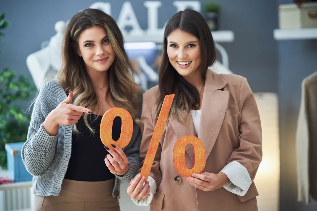 targeted discount programs two girls shopping holding sale percentage sign