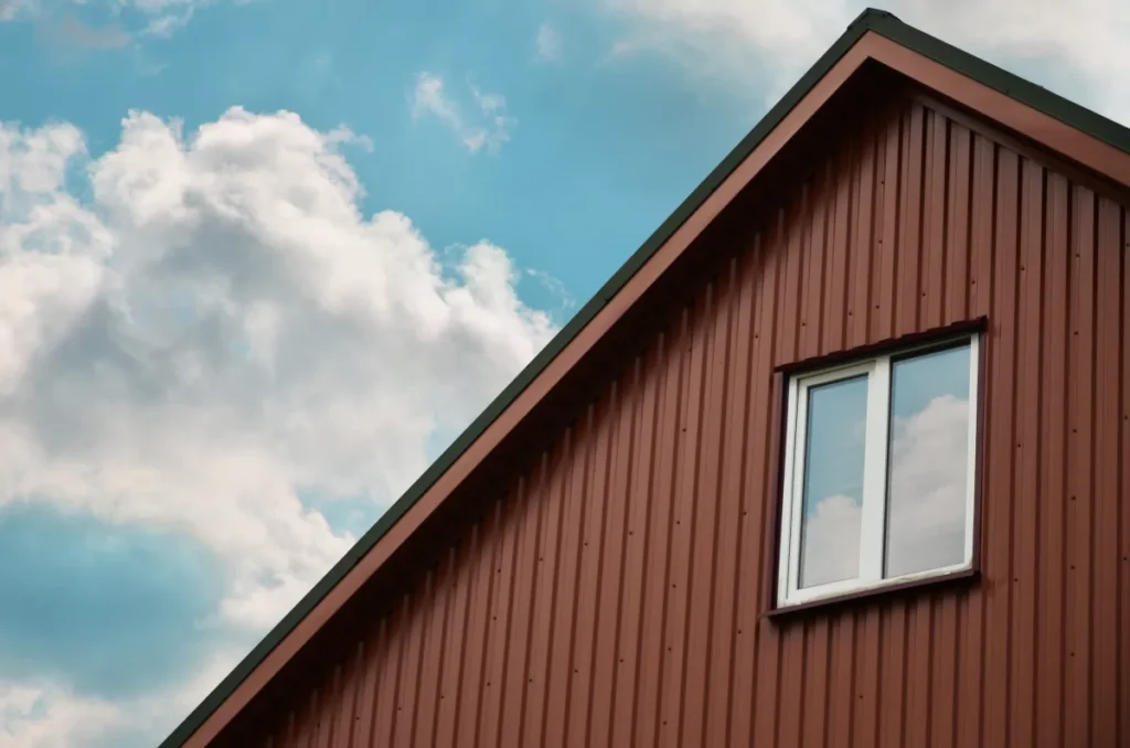 vertical siding the brown attic with a small window on the sky