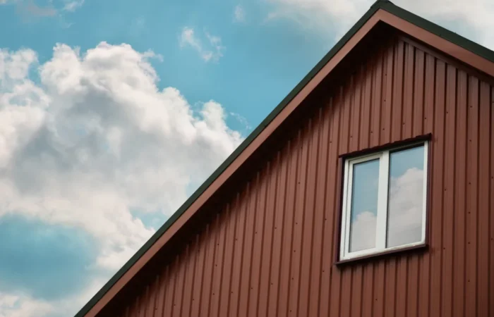 vertical siding the brown attic with a small window on the sky