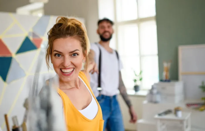 warranty post project support couple having fun when painting wall indoors ho