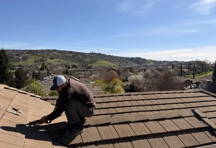 Technician performing tile roof leak repair in Folsom CA