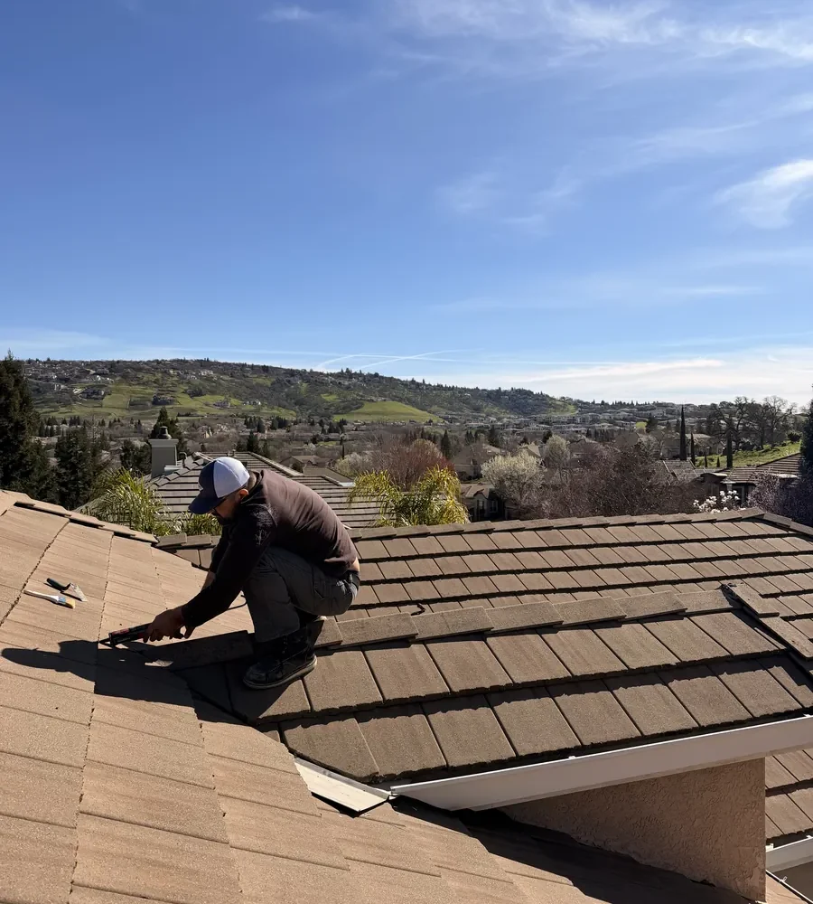 Technician performing tile roof leak repair in Folsom CA