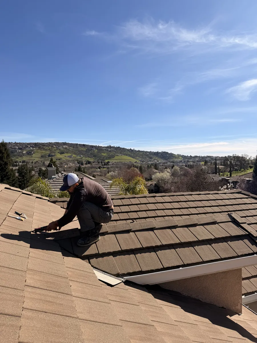 Technician performing tile roof leak repair in Folsom CA