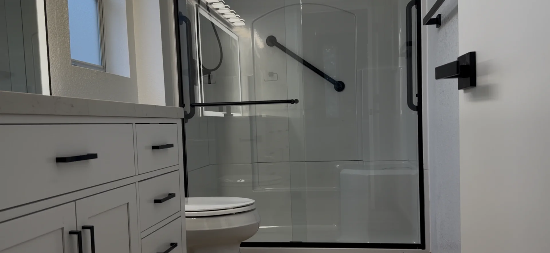 Completed Roseville bathroom remodel with a new shower enclosure, vanity, mirror, lighting, fixtures, and flooring.