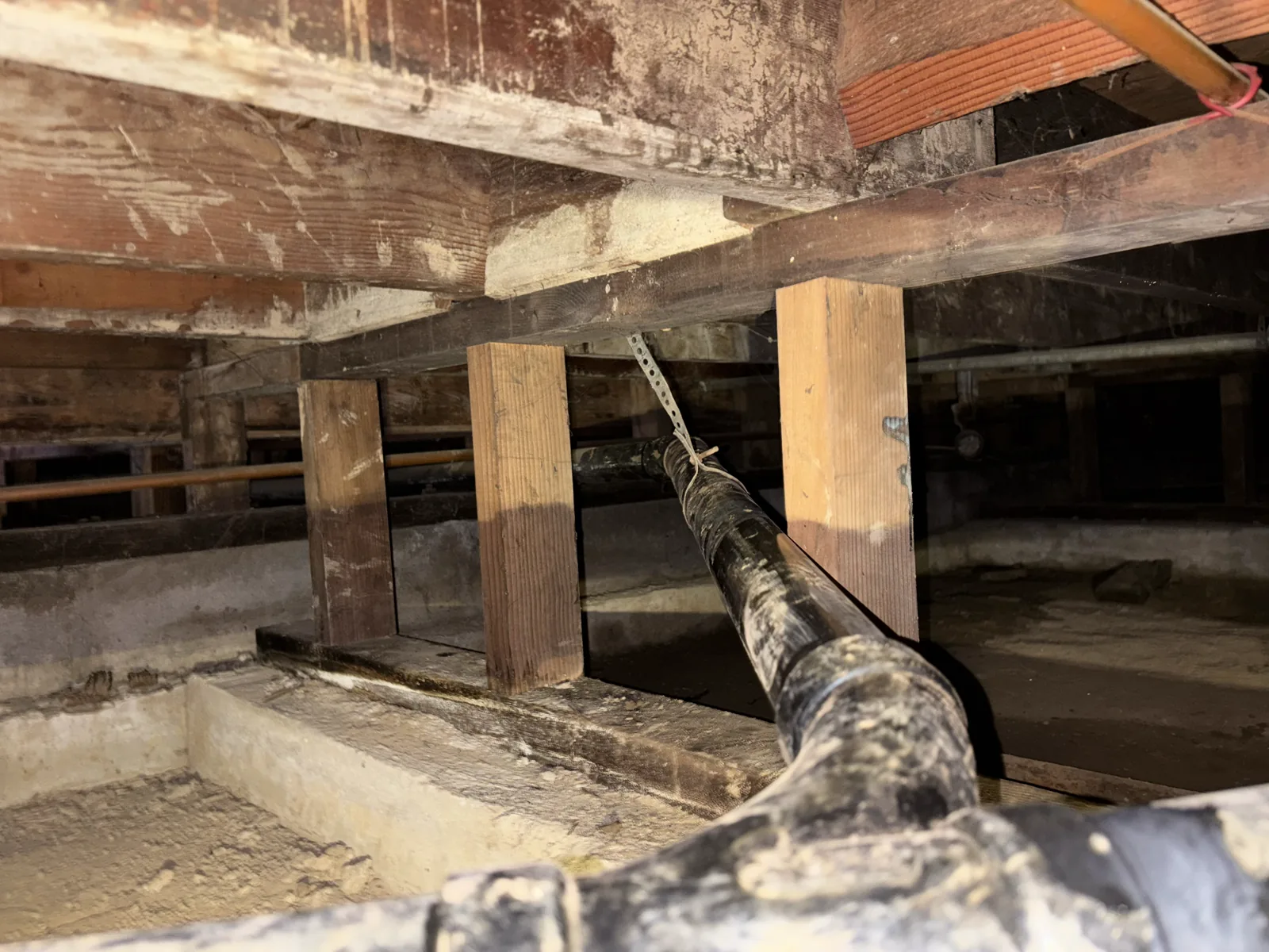Replacement drain line routed through a constrained residential crawlspace.