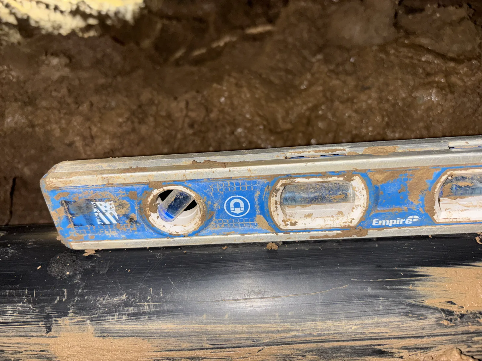 Close view of a level used on replacement drain piping during installation.