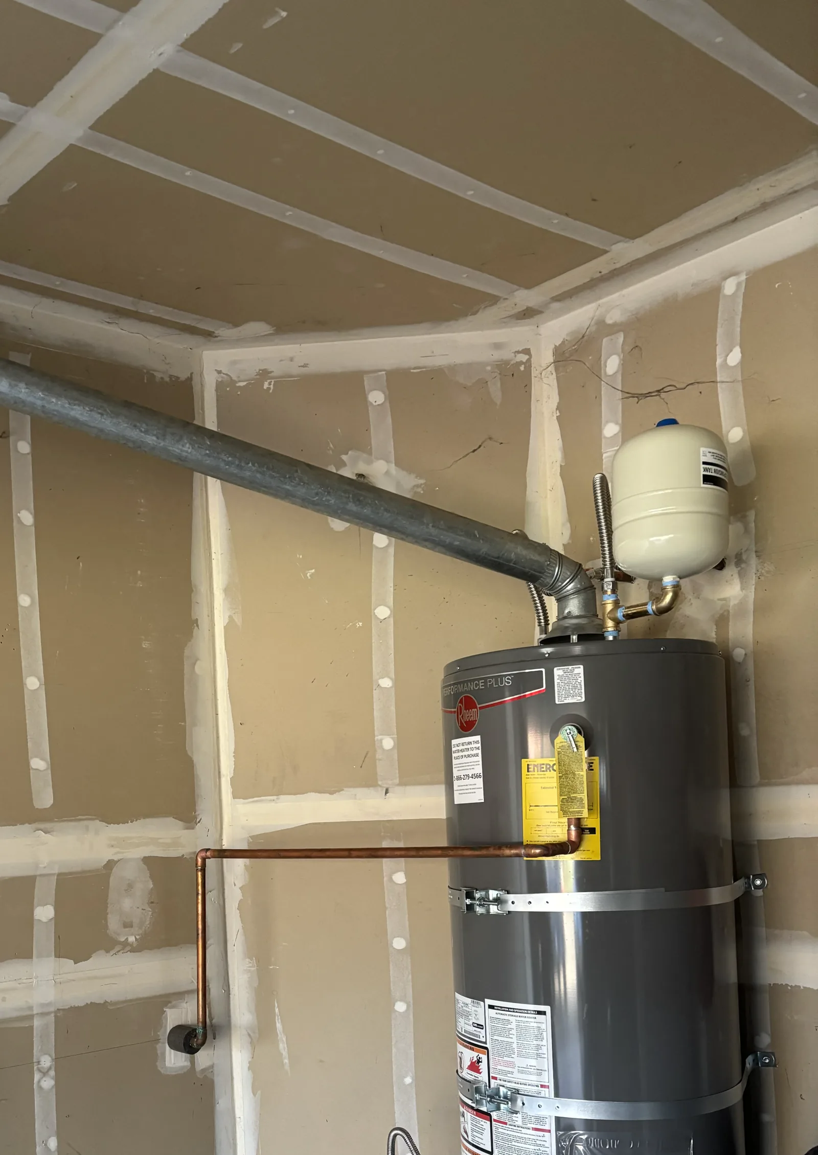 Replacement gas water heater showing the expansion tank, upper water connections, vent, and restraints in Folsom.