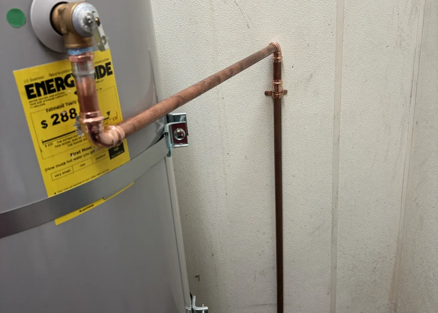 Existing commercial gas water heater with relief-discharge routing documented after the repair work.