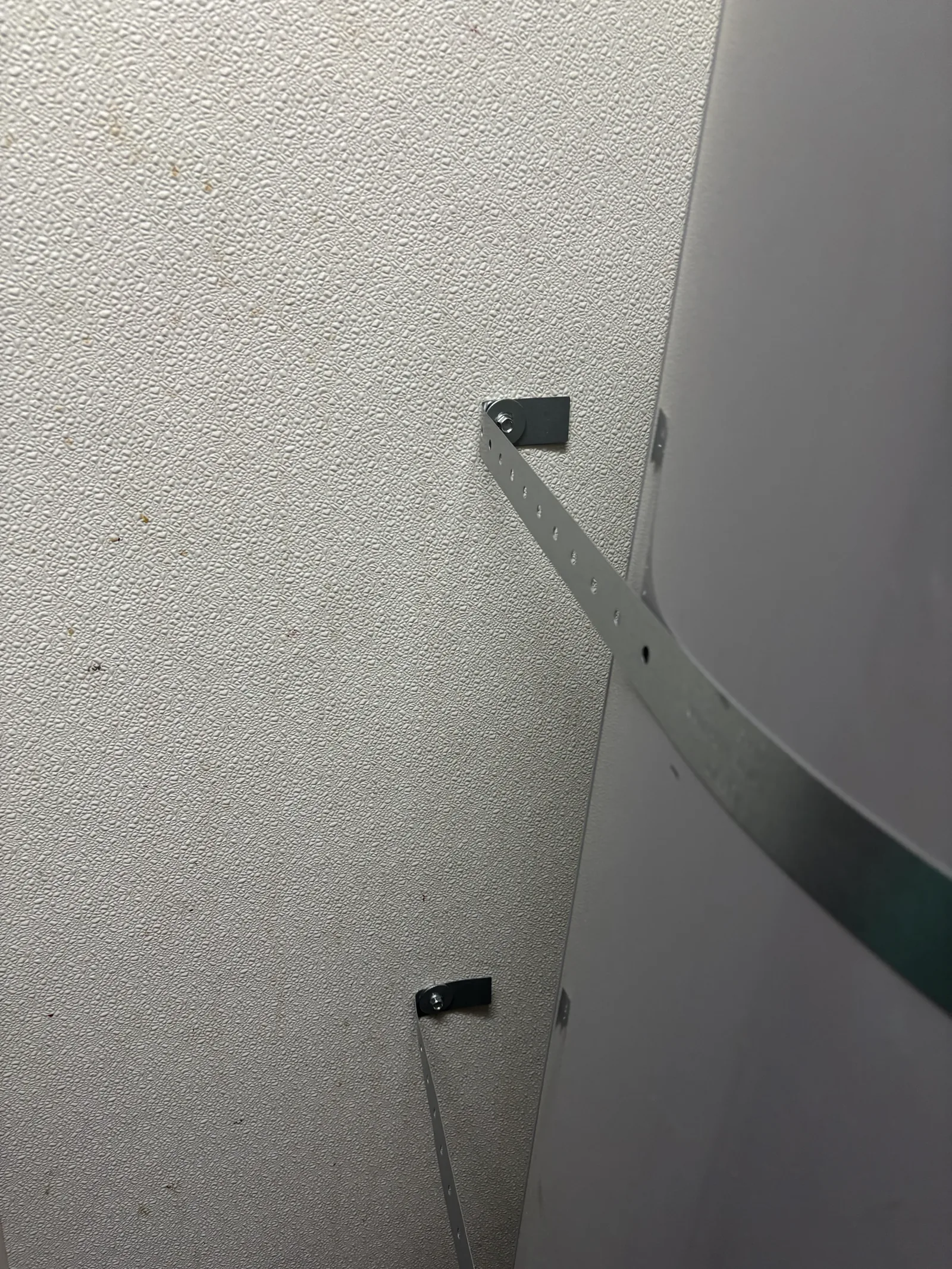 Upper seismic restraint anchor documented beside the commercial water heater.