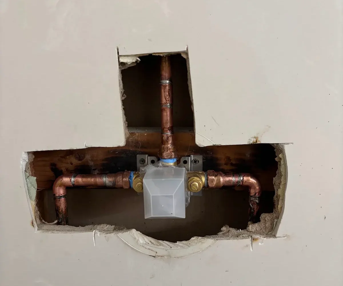 Opened shower wall showing a single-handle control and accessible copper connections during installation in Rocklin.