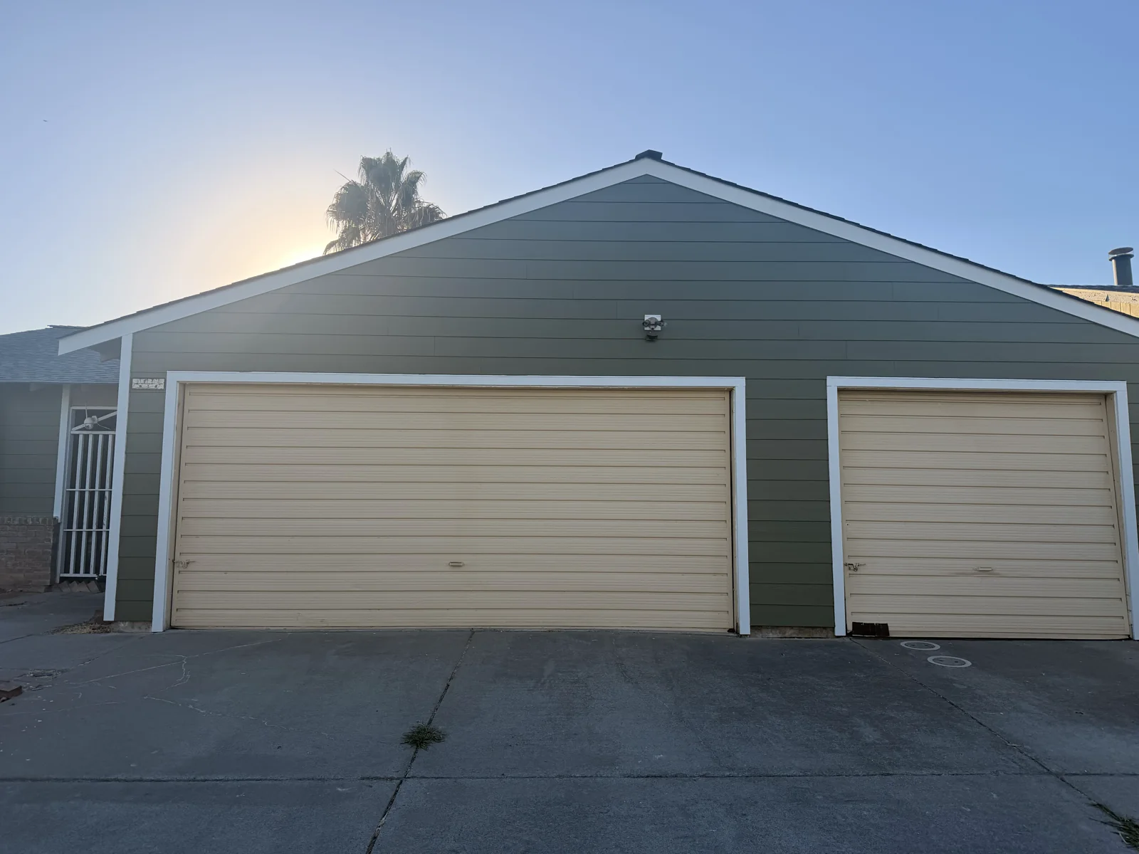 Completed lap siding and white trim across the two garage openings in Sacramento