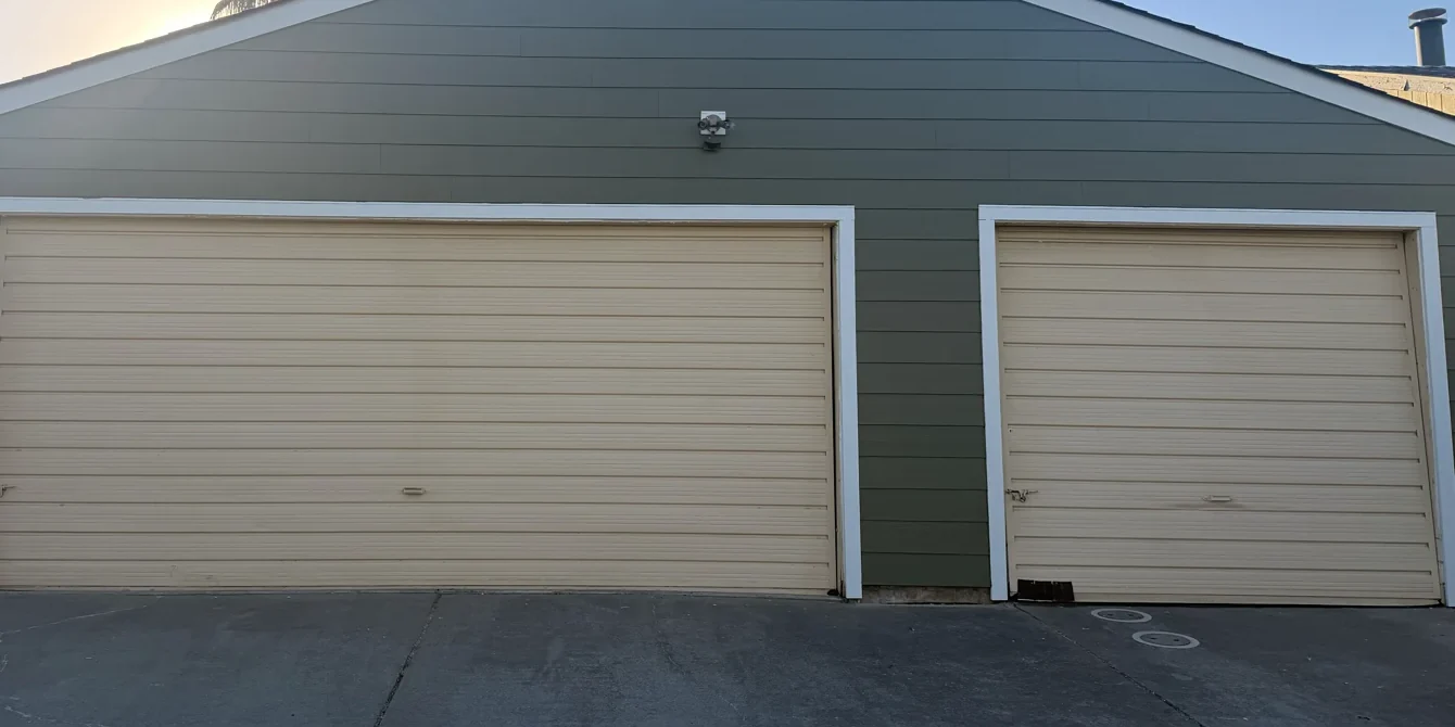 Completed horizontal James Hardie siding and white trim across the same Sacramento garage openings